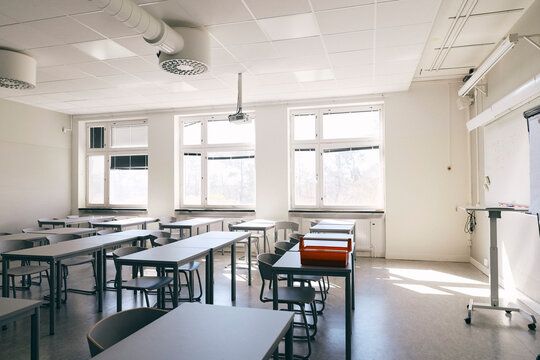 Empty desks and chairs in classroom at secondary school