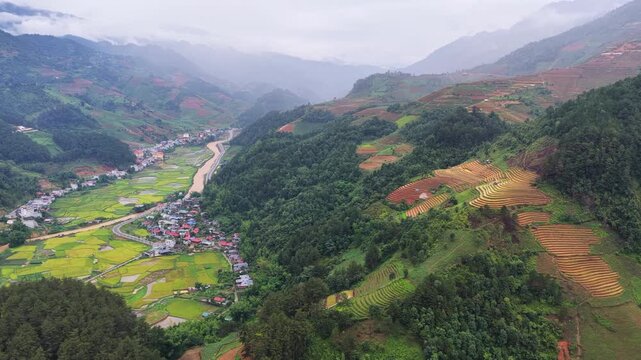 Aerial drone view of a hillside village surrounded by thick morning mist in Mu Cang Chai Vietnam