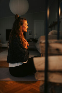 Side view of woman enjoying peaceful yoga session at home