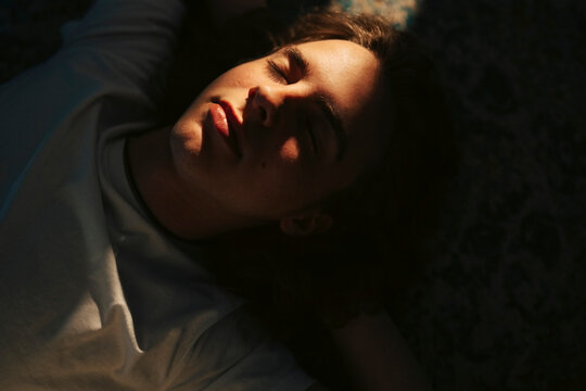 Carefree young man sleeping on floor at home