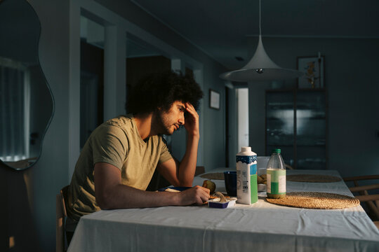 Lonely man dealing with loss of appetite while sitting at dining table