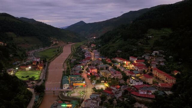 Aerial drone hyperlapse view of Mu Cang Chai town at dusk along the river in Vietnam