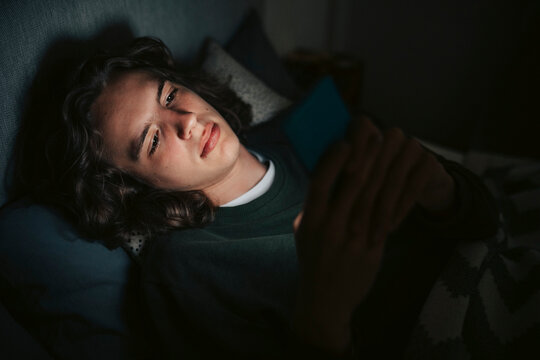 High angle view of young man using social media on smart phone