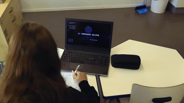 Female student sitting at her desk in a classroom while using an AI powered software on her laptop to get help with homework, showing the future of education and advanced learning technology
