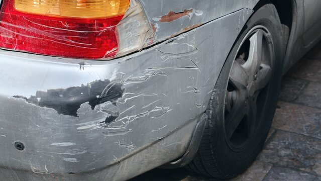 Car damage on rear lamp and bumper. Damaged car in a car repair shop.