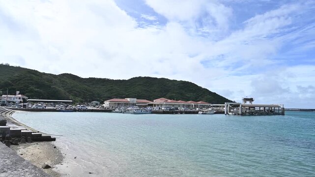 沖縄・座間味島の港から望む透明なエメラルドブルーの海と港町、慶良間諸島の離島風景【沖縄・座間味島風景動画】