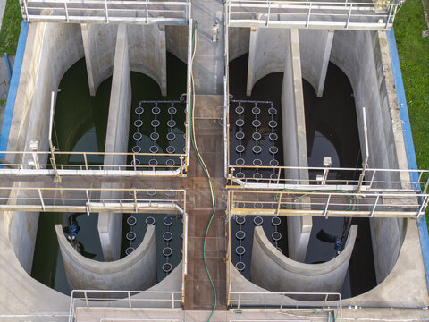 Aerial view of a wastewater treatment plant with concrete aeration tanks and industrial water filtration systems in Poland.