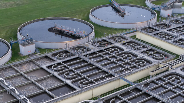 Aerial view of a wastewater treatment plant with circular sedimentation tanks and aeration basins in Poland.