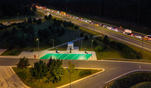 Aerial view of Gajewo East Motorway Service Area on A1 Motorway at night, with electric vehicle charging stations and green parking spots in Nowe, Kuyavian-Pomeranian, Poland.