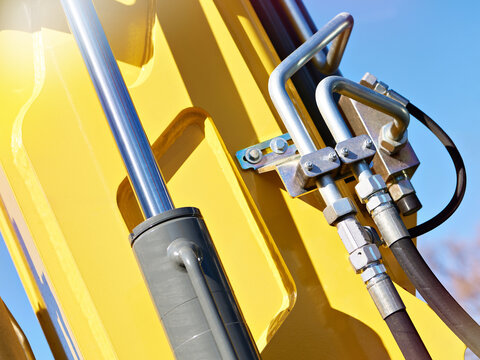 Hydraulic hoses and cylinder on yellow excavator