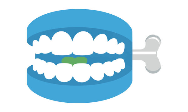 Retro wind-up chattering teeth toy with blue gums and green tongue isolated on white background playful childhood toy concept