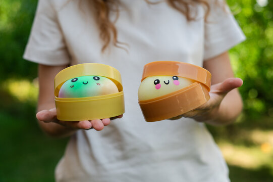 Girl holding cute dumpling squishies in steamer boxes in garden