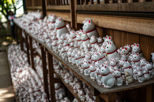 The row of maneki neko cat figurines at Gotokuji temple in Tokyo, Japan
