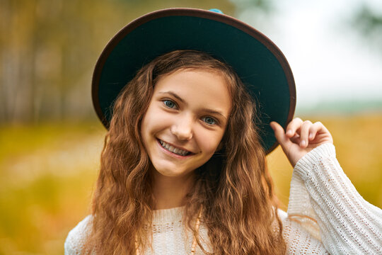 Smiling country girl adjusting blue hat