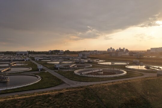 Aerial view of Berlin Water Works wastewater treatment plant Wassmannsdorf with circular sedimentation tanks and industrial infrastructure in Schonefeld, Brandenburg, Germany.