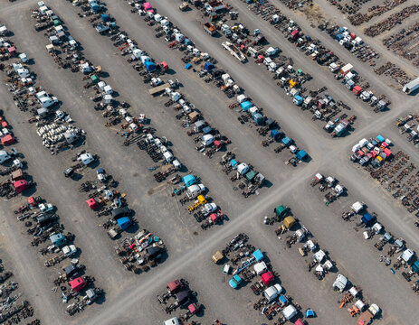 Aerial view of a large truck salvage yard with rows of semi-truck cabs and vehicle parts arranged in a gravel lot in Umatilla, Oregon, United States.