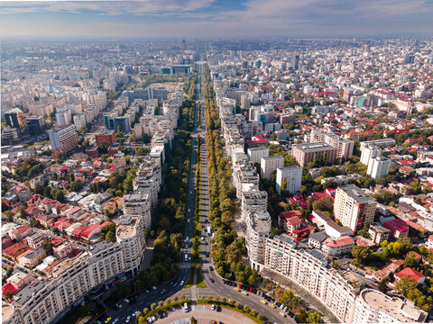 Aerial view of Unirii Boulevard, a long straight avenue lined with apartment blocks, trees, and urban traffic in Bucharest, Bucharest, Romania.