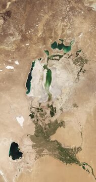 View from above on drying lake in arid region. Camera is zooming out, rotating counterclockwise. Vertical video. Animation based on image by NASA