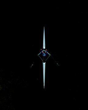 Aerial view of a professional rower in a single scull boat on dark water, preparing for the championship in Poland.
