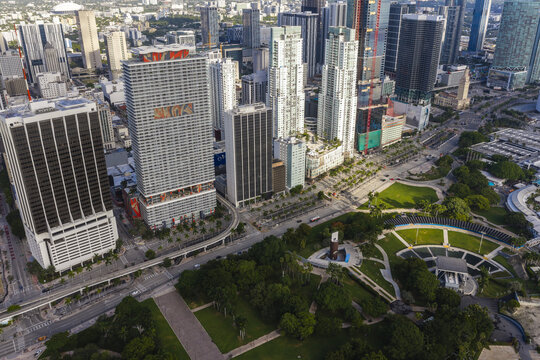 Aerial view of Downtown Miami featuring a dense cluster of modern skyscrapers, urban streets, and the green expanse of Bayfront Park in Miami, Florida, United States.