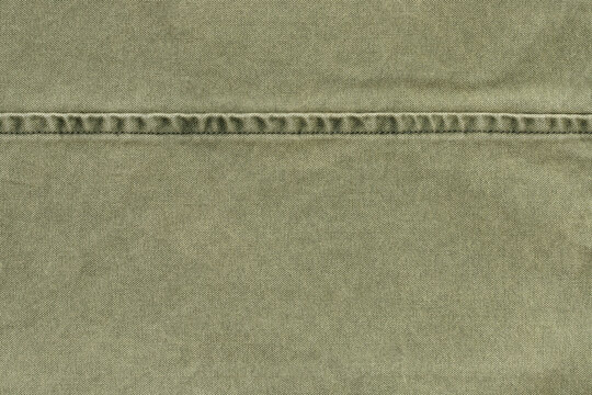 olive green canvas fabric texture close up background with stitched seam banner