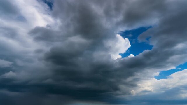 Dramatic dark storm clouds gather across the sky, revealing a small glimpse of bright blue.