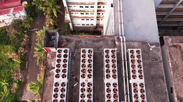 Aerial view of data center rooftop equipped with heavy-duty cooling units, industrial ventilation fans, condenser systems, and pipes for temperature control. Ideal for commercial technology, industria