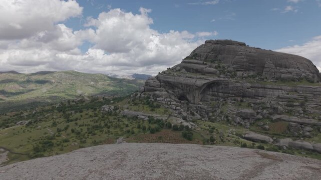 Drone rises smoothly from the ground, revealing a dramatic green valley. Captured in a flat color profile, ideal for professional color grading and LUT workflows.