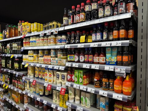 Mallorca, spain, august 30, 2026, supermarket aisle displaying rows of sauces, mayonnaise, mustard, and oils for sale in andratx, spain