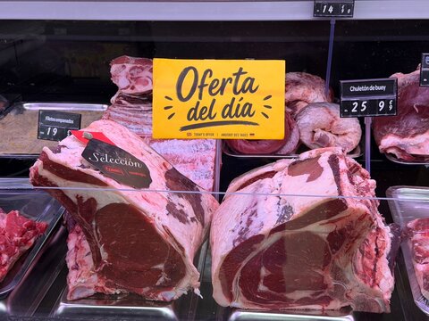 Mallorca, spain, august 30, 2026, butcher shop meat counter displaying fresh chuleton de buey with oferta del dia sign in andratx, spain
