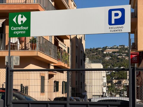 Mallorca, spain, august 30, 2026, carrefour express parking sign with exclusivo clientes message and blue p symbol in andratx, spain