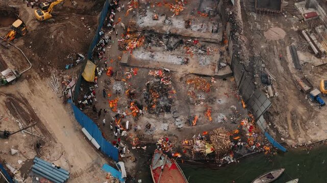 Aerial view of hindu cremation ritual at manikarnika ghat in varanasi, india, with funeral pyres burning on the ganges river bank