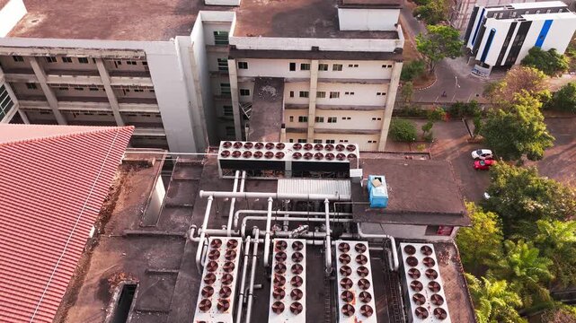 Aerial view of data center rooftop equipped with heavy-duty cooling units, industrial ventilation fans, condenser systems, and pipes for temperature control. Ideal for commercial technology, industria