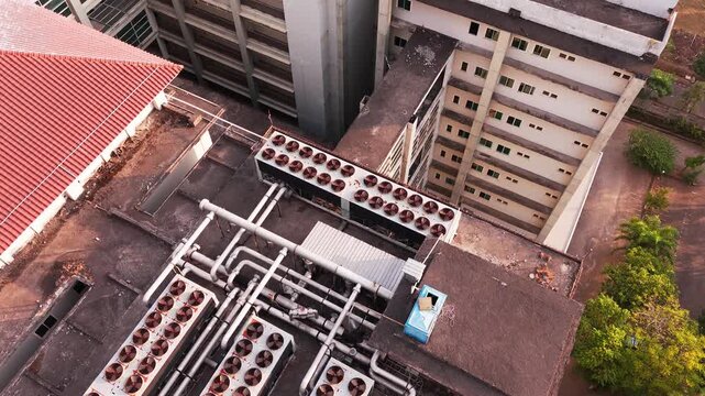 Aerial view of data center rooftop equipped with heavy-duty cooling units, industrial ventilation fans, condenser systems, and pipes for temperature control. Ideal for commercial technology, industria