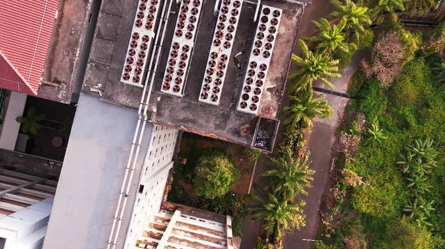 Aerial view of data center rooftop equipped with heavy-duty cooling units, industrial ventilation fans, condenser systems, and pipes for temperature control. Ideal for commercial technology, industria