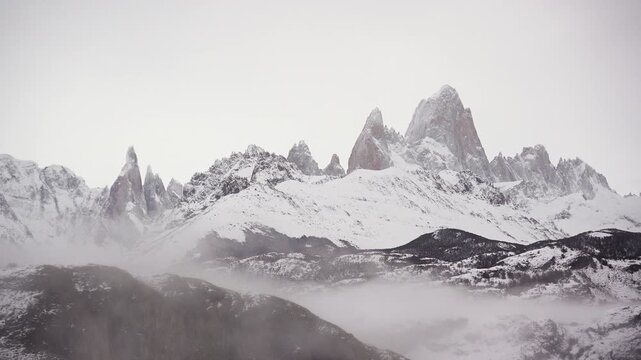 WinterTime lapse of Mount Fitz Roy and Cerro Torre peaks surrounded by clouds with cold weather in Los Glaciares National Park