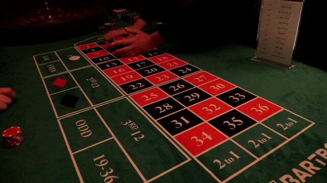 Close view of a roulette table during an elegant casino themed event with a hand placing a bet