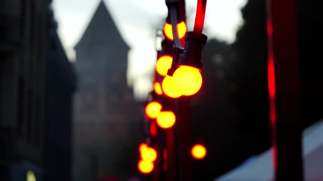 Warm decorative string lights glowing outside a restaurant in the evening creating a cozy urban atmosphere