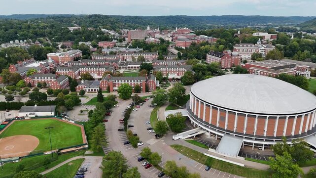 Drone footage of Ohio University in Athen, Ohio on a sunny day featuring the convocation center and many campus buildings.