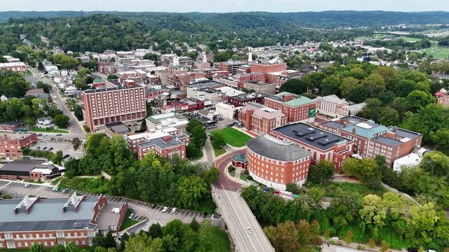 Drone footage of Ohio University in Athen, Ohio on a sunny day featuring the convocation center and many campus buildings.