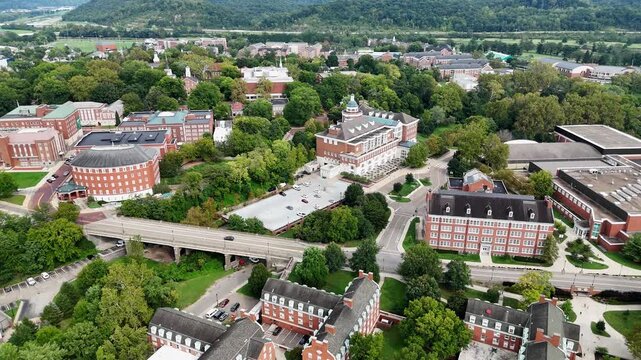Drone footage of Ohio University in Athen, Ohio on a sunny day featuring the convocation center and many campus buildings.