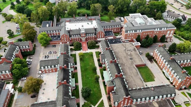 Drone footage of Ohio University in Athen, Ohio on a sunny day featuring the convocation center and many campus buildings.