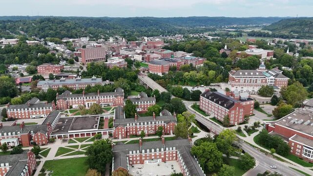 Drone footage of Ohio University in Athen, Ohio on a sunny day featuring the convocation center and many campus buildings.