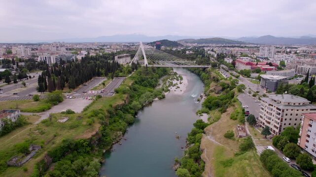 Morača River and Millennium Bridge crossing central Podgorica urban districts in Montenegro, aerial