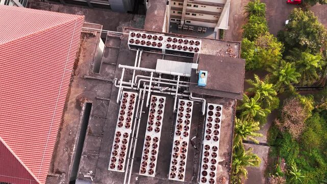 Aerial view of data center rooftop equipped with heavy-duty cooling units, industrial ventilation fans, condenser systems, and pipes for temperature control. Ideal for commercial technology, industria
