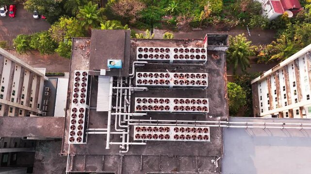 Aerial view of data center rooftop equipped with heavy-duty cooling units, industrial ventilation fans, condenser systems, and pipes for temperature control. Ideal for commercial technology, industria