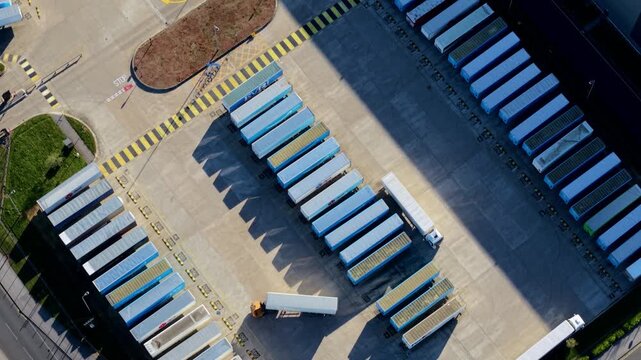 Aerial view of HGVs lined up at warehouse loading bays with lorries parking and maneuvering in yard
