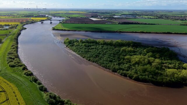 Top down drone perspective of turbid muddy currents swirling around uninhabited island in Yorkshire