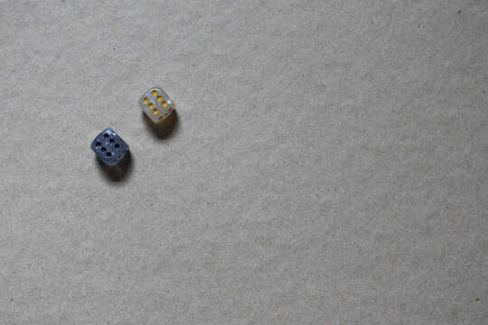 Two dice on a brown surface showing numbers