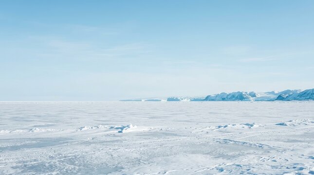 A wide, expansive view of a bright, icy landscape. A vast, flat expanse of white snow and ice stretches out to the horizon.